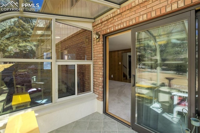 view of exterior entry featuring brick siding