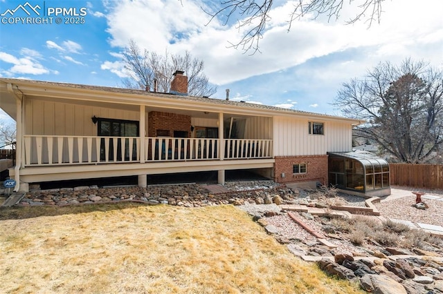 exterior space with a chimney, fence, and brick siding