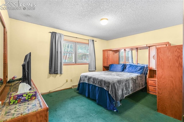 bedroom featuring a textured ceiling, carpet flooring, and visible vents