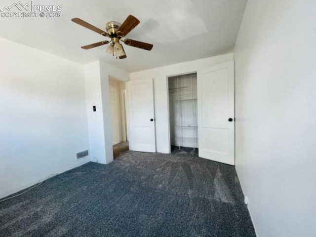 unfurnished bedroom with ceiling fan, dark colored carpet, a closet, and visible vents