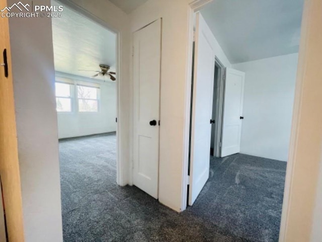 hallway featuring dark colored carpet