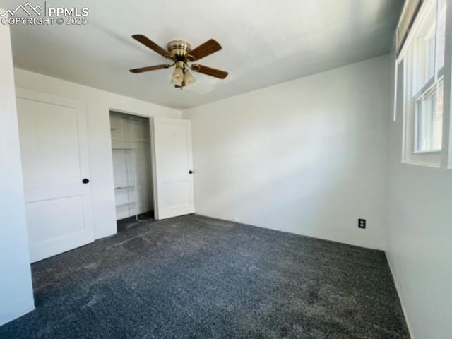 unfurnished bedroom featuring a ceiling fan, dark colored carpet, and a closet