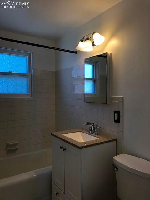 bathroom with toilet, bathing tub / shower combination, backsplash, and vanity