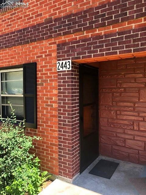 view of exterior entry with brick siding