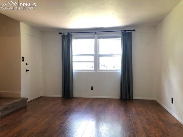 unfurnished room with baseboards and hardwood / wood-style floors