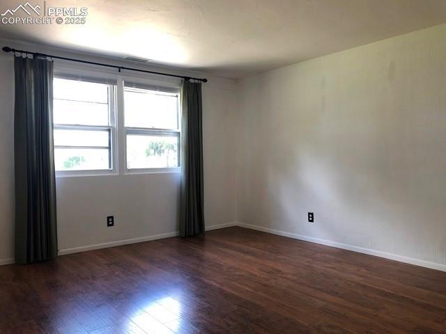 unfurnished room featuring baseboards and wood finished floors