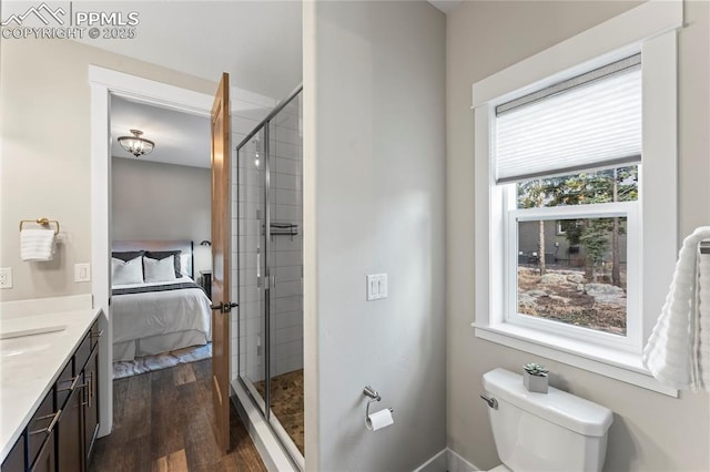 ensuite bathroom with wood finished floors, a stall shower, ensuite bath, and vanity