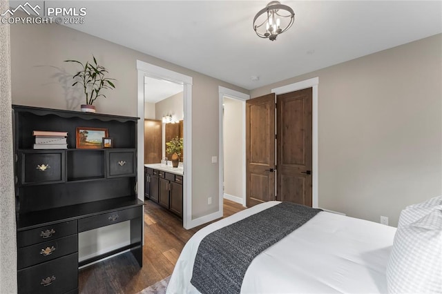 bedroom featuring dark wood-style floors, ensuite bath, and baseboards