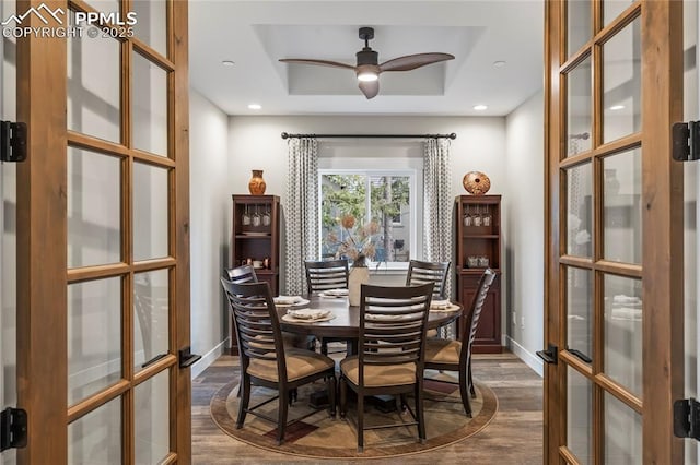 dining area with recessed lighting, dark wood-type flooring, baseboards, french doors, and a tray ceiling