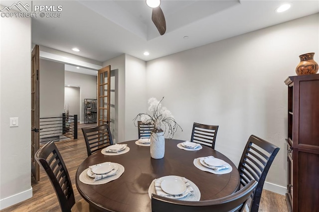 dining space featuring baseboards, wood finished floors, and recessed lighting