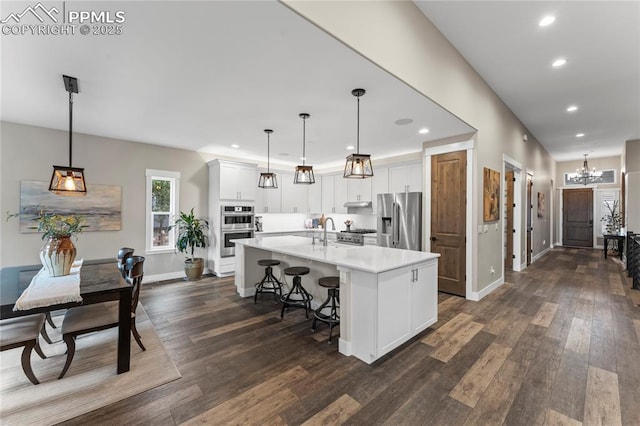 kitchen with stainless steel appliances, dark wood-type flooring, light countertops, and white cabinetry