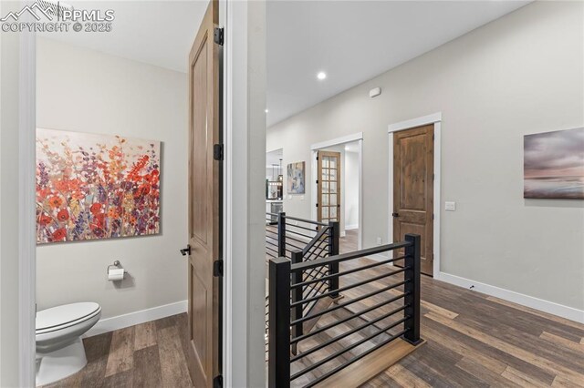 hall with recessed lighting, wood finished floors, an upstairs landing, and baseboards