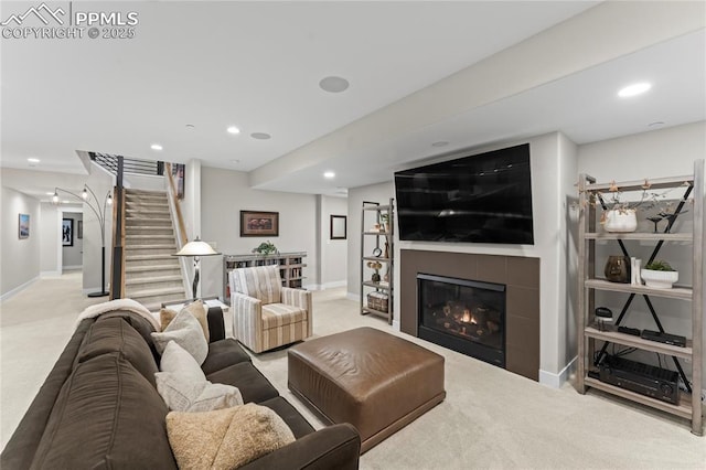 carpeted living room with recessed lighting, stairs, baseboards, and a tile fireplace