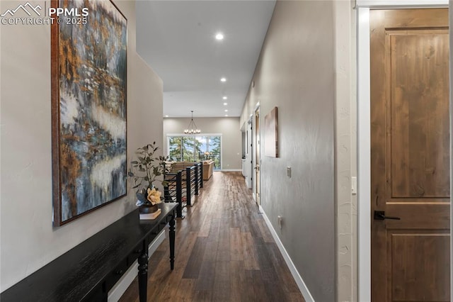 hallway with a chandelier, recessed lighting, dark wood finished floors, and baseboards