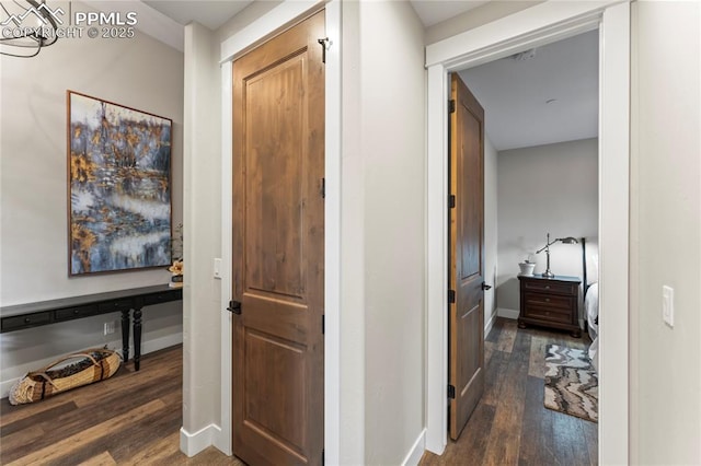 hallway with dark wood-type flooring and baseboards