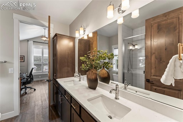 full bath with wood finished floors, a stall shower, a sink, and baseboards