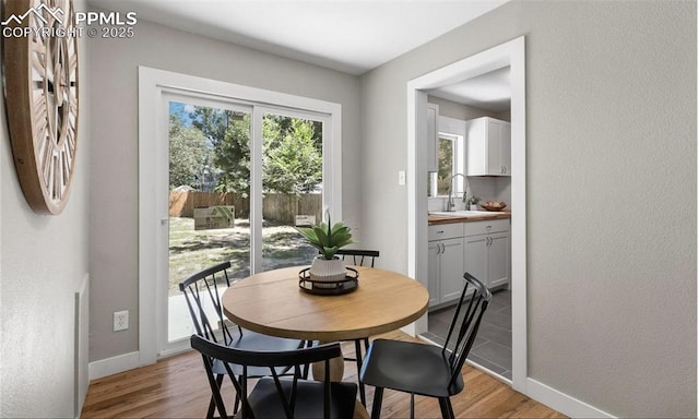 dining area featuring light wood-type flooring and baseboards