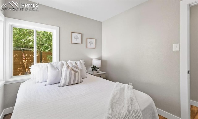 bedroom with wood finished floors and baseboards