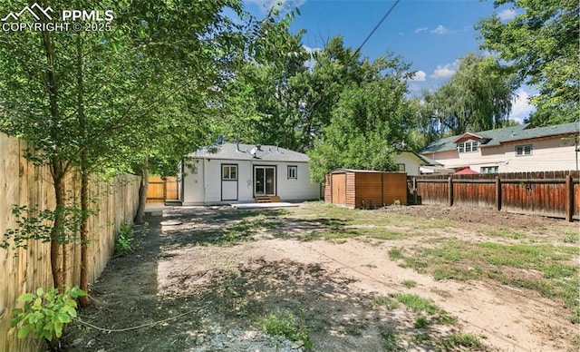 view of yard with an outbuilding, a fenced backyard, and a storage unit