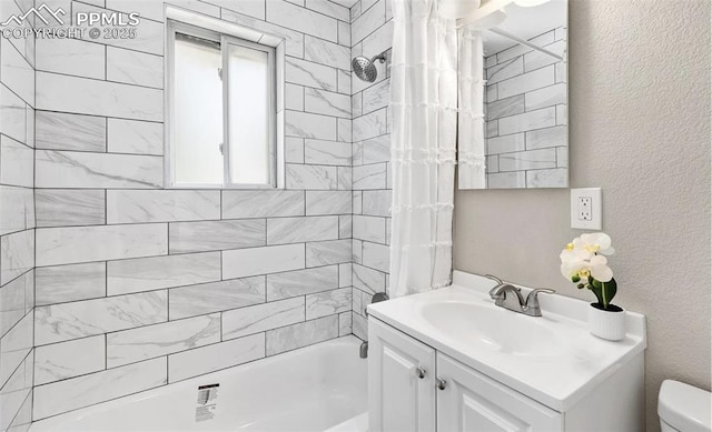 bathroom with a textured wall, shower / tub combo with curtain, vanity, and toilet