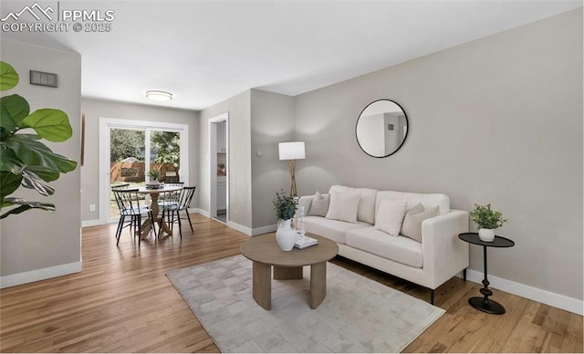 living room featuring light wood-style flooring and baseboards