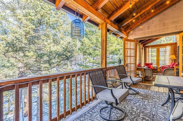 sunroom featuring vaulted ceiling with beams and wooden ceiling