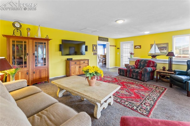 carpeted living area with attic access and baseboards