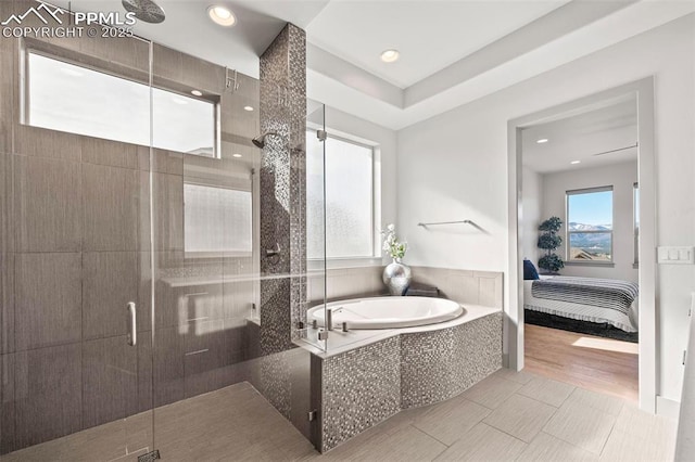 bathroom featuring connected bathroom, wood finished floors, a garden tub, a shower stall, and recessed lighting