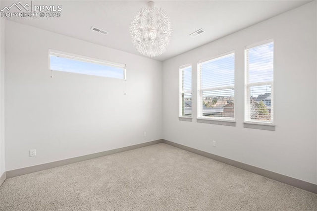 empty room featuring carpet floors, visible vents, and baseboards