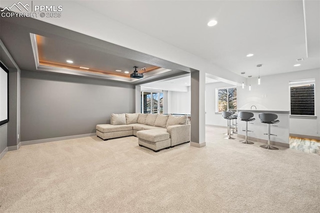 carpeted living room with baseboards, a raised ceiling, and recessed lighting