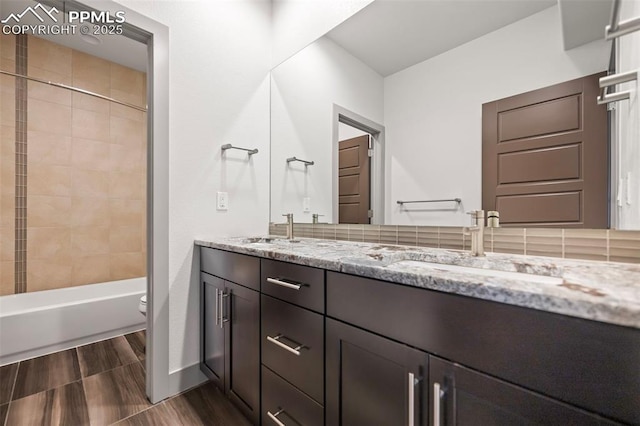 full bath with shower / bathtub combination, a sink, toilet, and double vanity