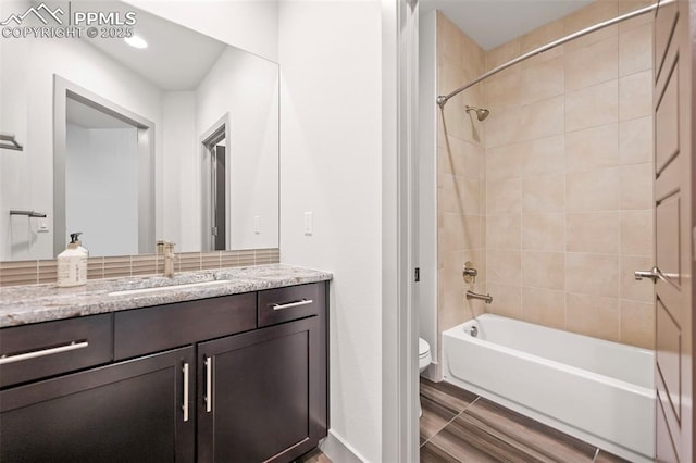 bathroom featuring toilet,  shower combination, and vanity