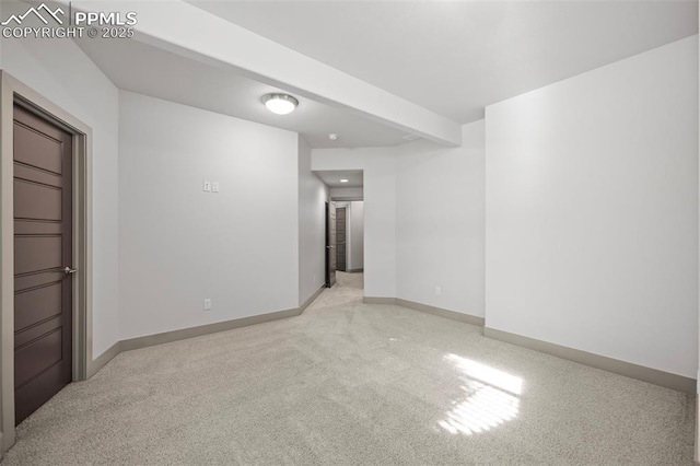 spare room with light carpet and baseboards