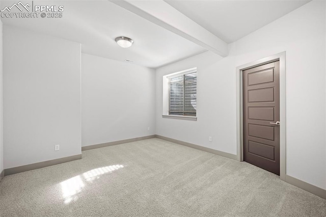 carpeted spare room featuring beam ceiling and baseboards