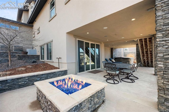 view of patio with a fire pit and outdoor dining area