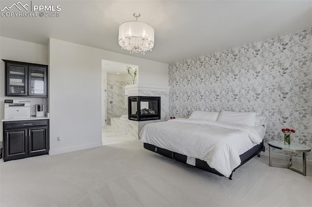 bedroom featuring a chandelier, a fireplace, carpet flooring, baseboards, and wallpapered walls