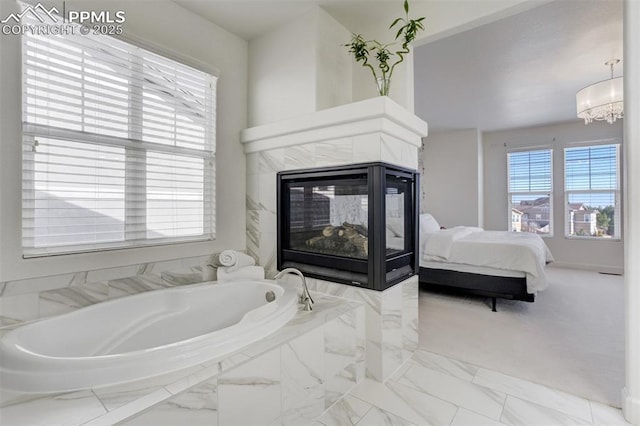 bedroom with marble finish floor, a fireplace, and a notable chandelier