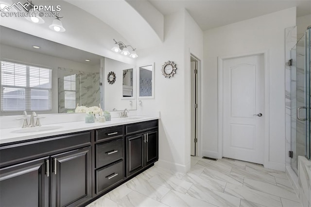 bathroom with double vanity, a marble finish shower, baseboards, marble finish floor, and a sink