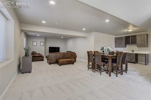 dining area featuring light carpet, baseboards, bar area, and recessed lighting