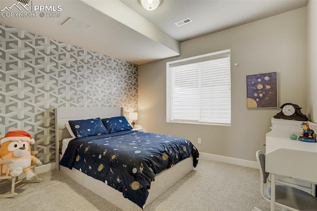 carpeted bedroom with an accent wall, visible vents, baseboards, and wallpapered walls