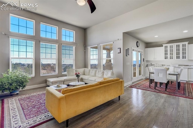 living room with a ceiling fan, recessed lighting, baseboards, and wood finished floors