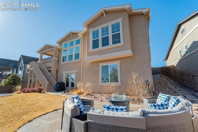 back of property featuring an outdoor hangout area, fence, stairs, a lawn, and stucco siding