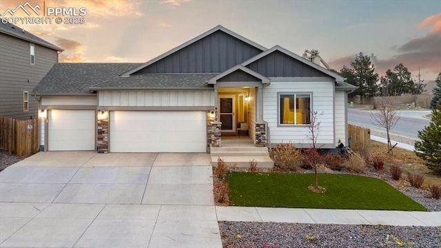 view of front of house with a garage, concrete driveway, roof with shingles, fence, and board and batten siding