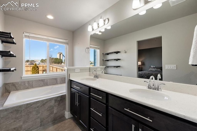 bathroom featuring a garden tub, a sink, ensuite bath, and double vanity