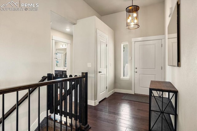 foyer entrance featuring dark wood finished floors and baseboards