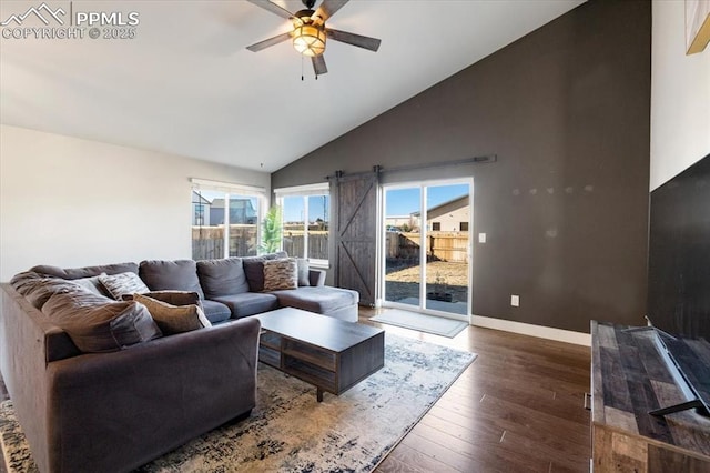 living room with a barn door, baseboards, a ceiling fan, wood-type flooring, and high vaulted ceiling