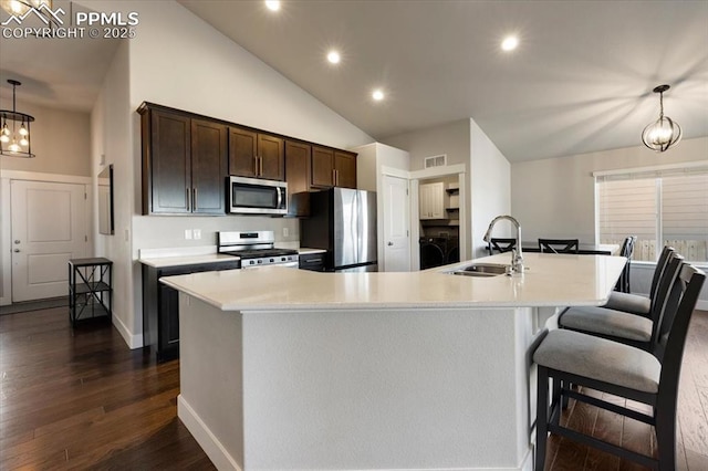 kitchen featuring dark wood-type flooring, a sink, dark brown cabinets, appliances with stainless steel finishes, and light countertops