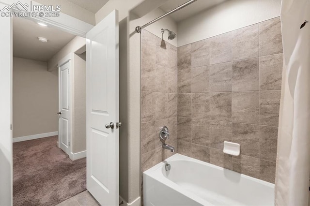 bathroom with washtub / shower combination and baseboards