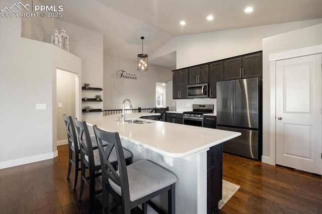 kitchen with lofted ceiling, dark wood-style floors, stainless steel appliances, light countertops, and a sink