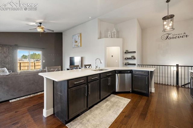 kitchen with light countertops, stainless steel dishwasher, dark wood-type flooring, open floor plan, and a sink